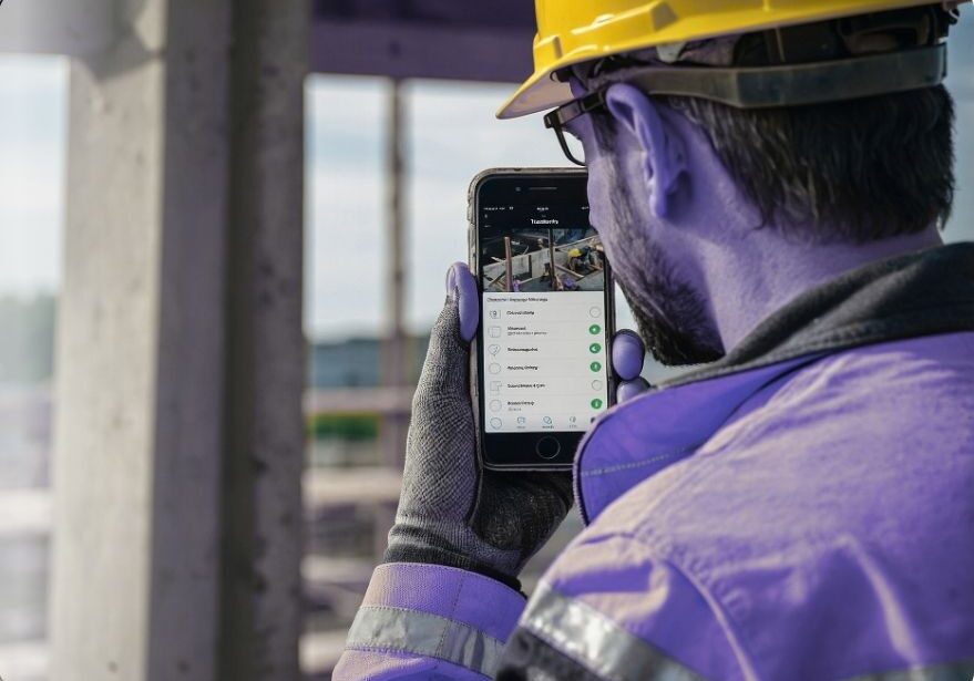 Construction worker using smartphone outdoors for mobile access in construction