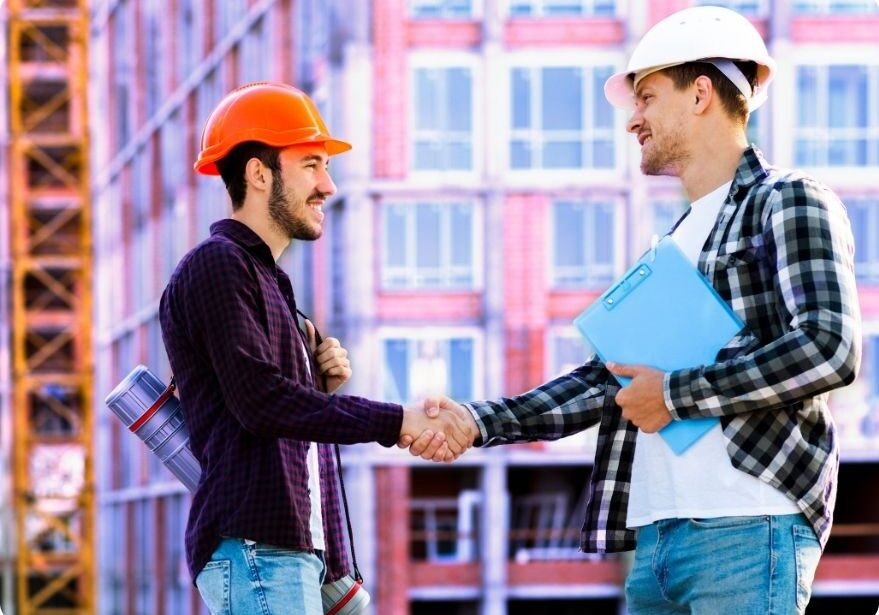 Two construction workers shaking hands.