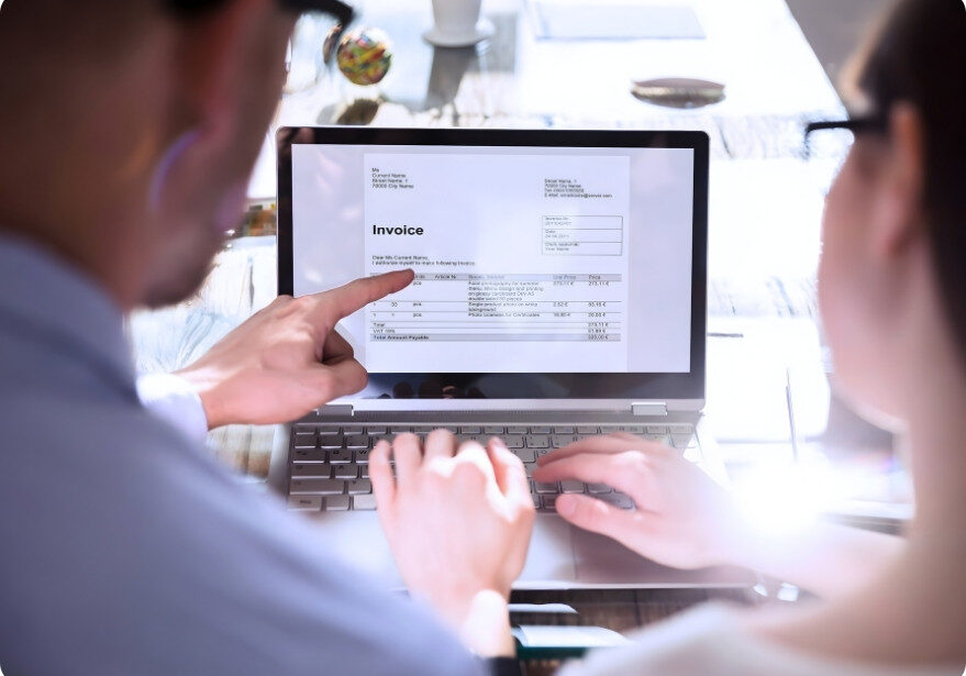 Reviewing an invoice on a laptop.